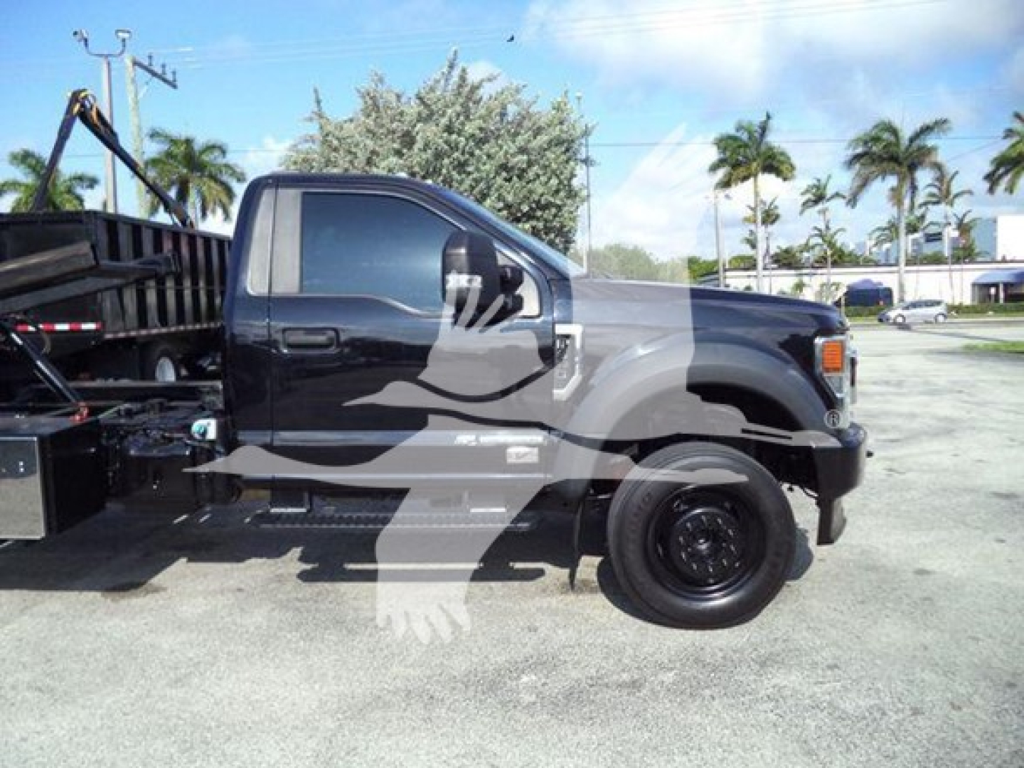Ford F-600 rollback truck side view showing cab and wheel, with white dealership watermark over the image.
