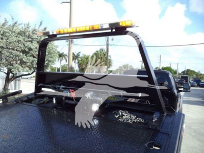 Truck bed of a 2022 Ford F600 rollback showing a safety bar and reflective light bar on top with a patterned back grid.