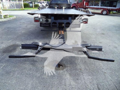 Rear view of a 2022 Ford F600 rollback truck showing the towing hitch and chassis undercarriage components.