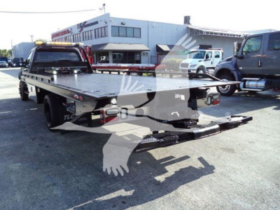 Ford F-600 rollback truck flatbed with rear loading ramps and platform, viewed from rear three-quarter angle.