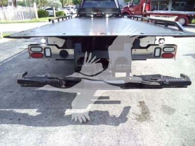 Rear view of a 2022 Ford F600 rollback truck showing bumper, taillights, and a flatbed with mounting hardware; no legible text visible on labels in image.