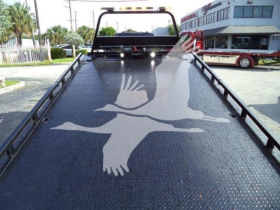 Truck bed of a Ford F600 rollback showing a large bird graphic on a textured metal surface.
