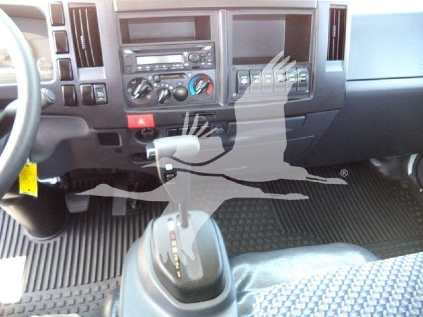 Isuzu NPRR dashboard and gear shifter showing center console and controls.
