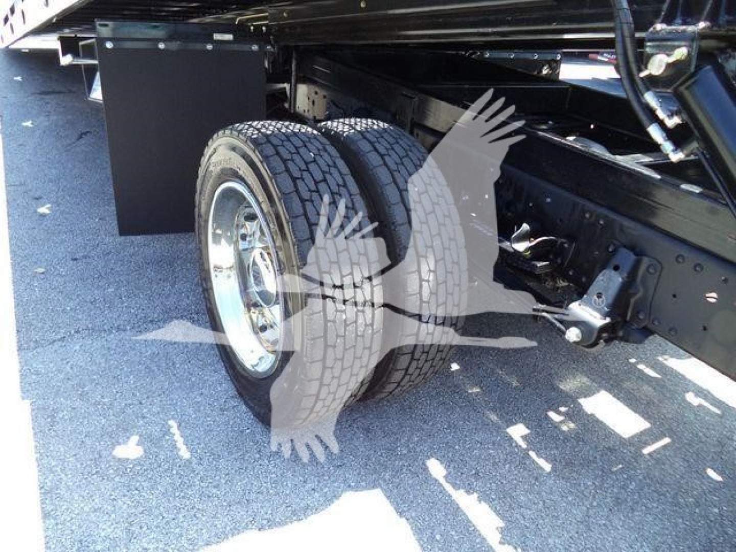 Isuzu NPRR rollback truck rear dual wheels and undercarriage view showing tires and suspension components.