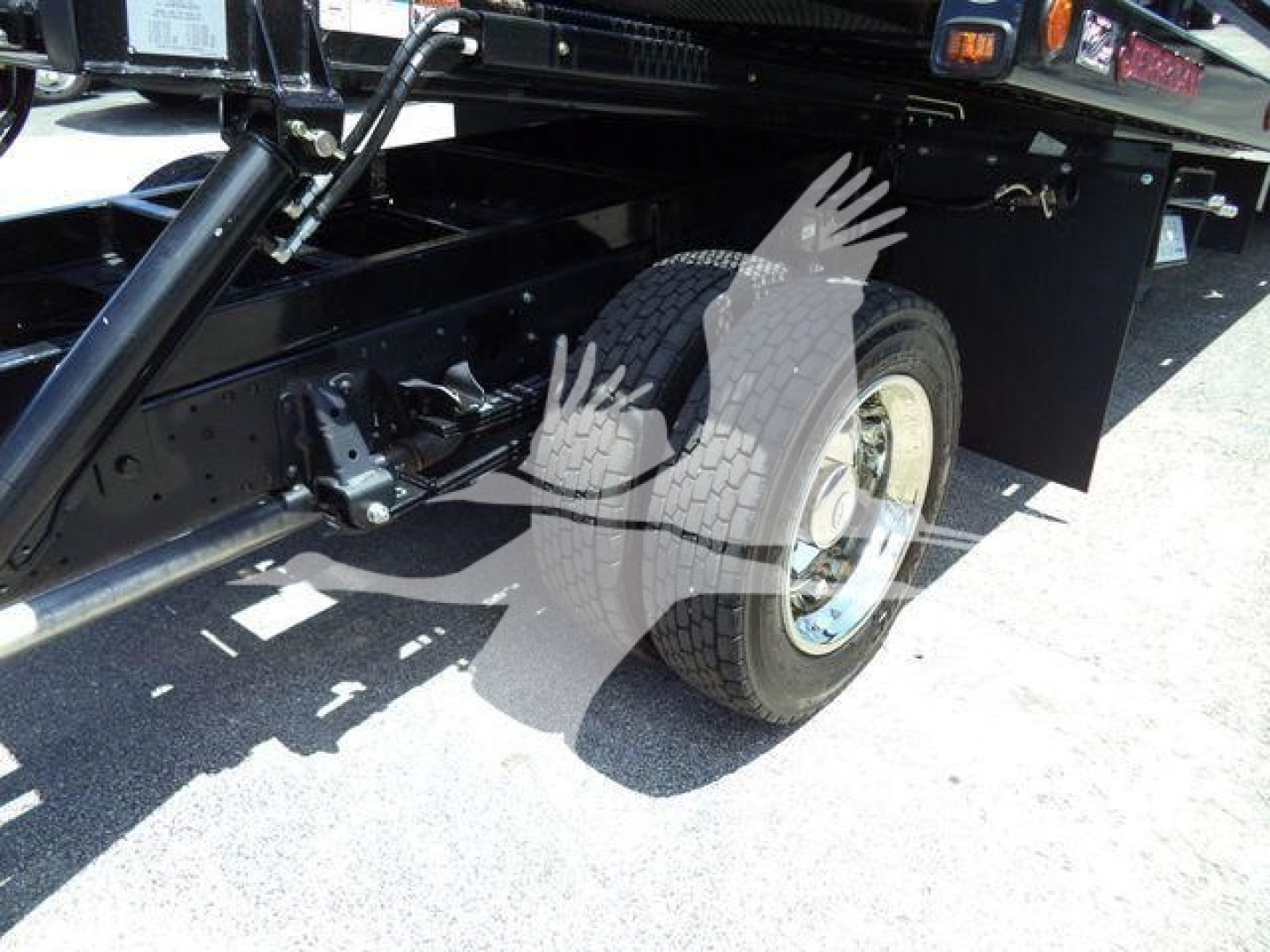 Isuzu NPRR rollback truck rear wheel and undercarriage showing suspension and frame components.