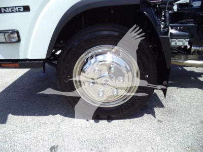 Isuzu NRR truck front wheel area showing chrome hubcap and tire; partial fender with NRR badge visible