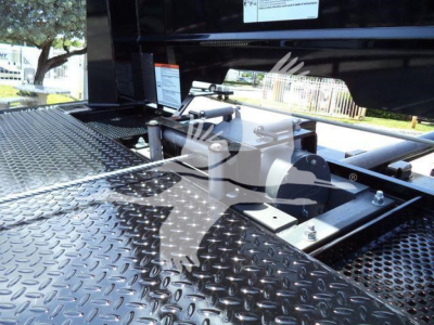 Isuzu NPRR rollback truck chassis with diamond plate surface and hydraulic components visible.