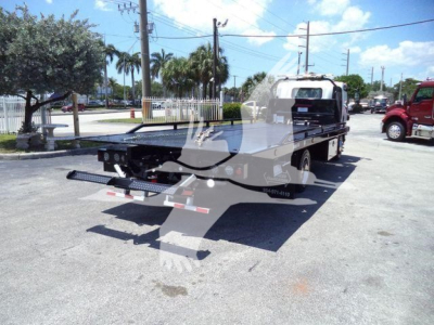 Isuzu NPRR rollback tow truck rear view showing flatbed and equipment, with decals and light bar.
