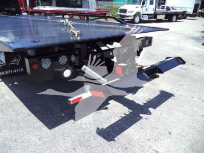 Isuzu NRR rollback truck rear view showing hydraulic ramp and platform with metal diamond plate surface.