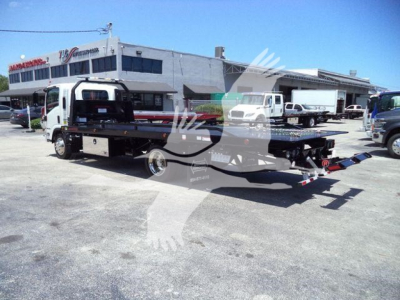 Isuzu NPR/NRR rollback tow truck with a flatbed and branding on building in background.