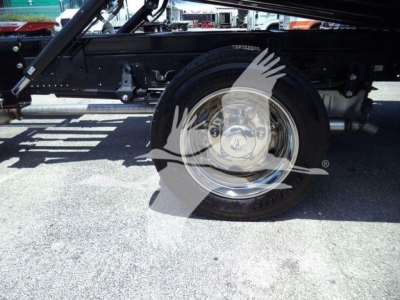 Isuzu NRRGAS22XLP rollback truck wheel and frame visible, chrome wheel, black chassis, undercarriage components.