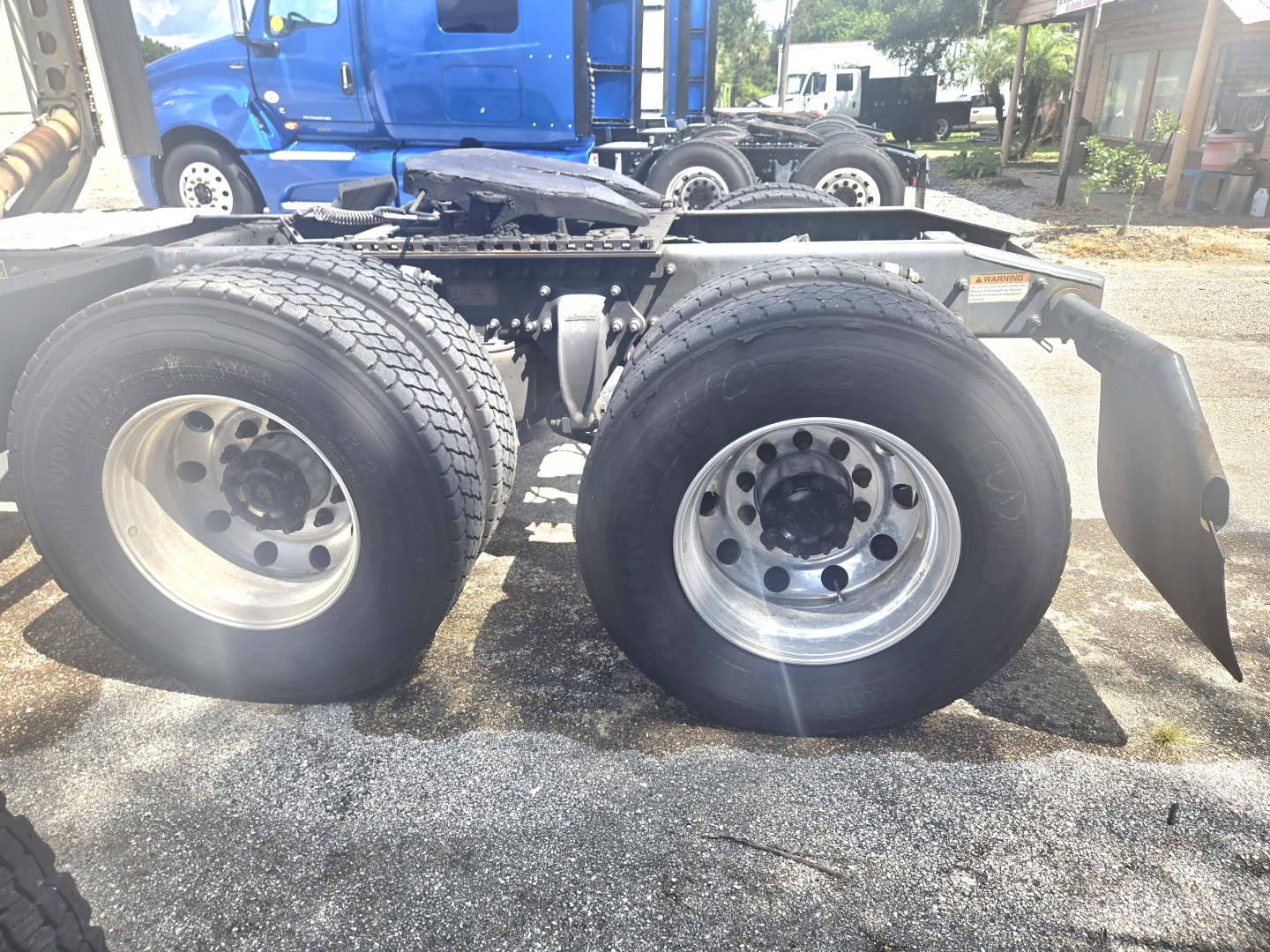 Dual rear wheels on a Freightliner Cascadia chassis showing tires, rims, and suspension components.