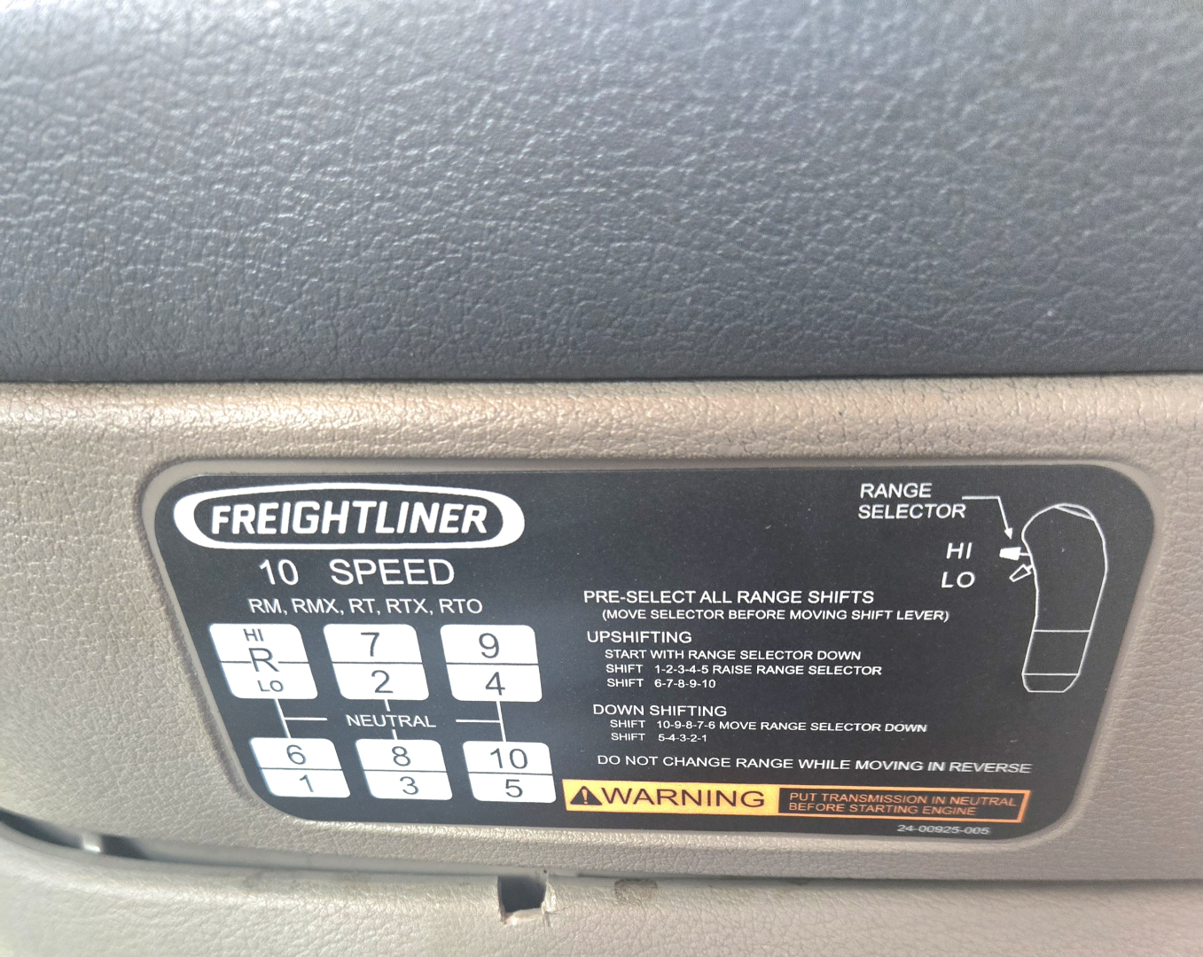 Freightliner gear shift panel showing range selector with digits 1-8 and letters R N with 10 speed emblem and warning label.