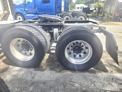 Dual rear wheels on a Freightliner Cascadia chassis showing tires, rims, and suspension components.