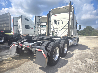 Horsepower-tagged Freightliner Cascadia midroof tractor rear view showing dual rear axles and fifth wheel mounting with mud flaps and step hoses.