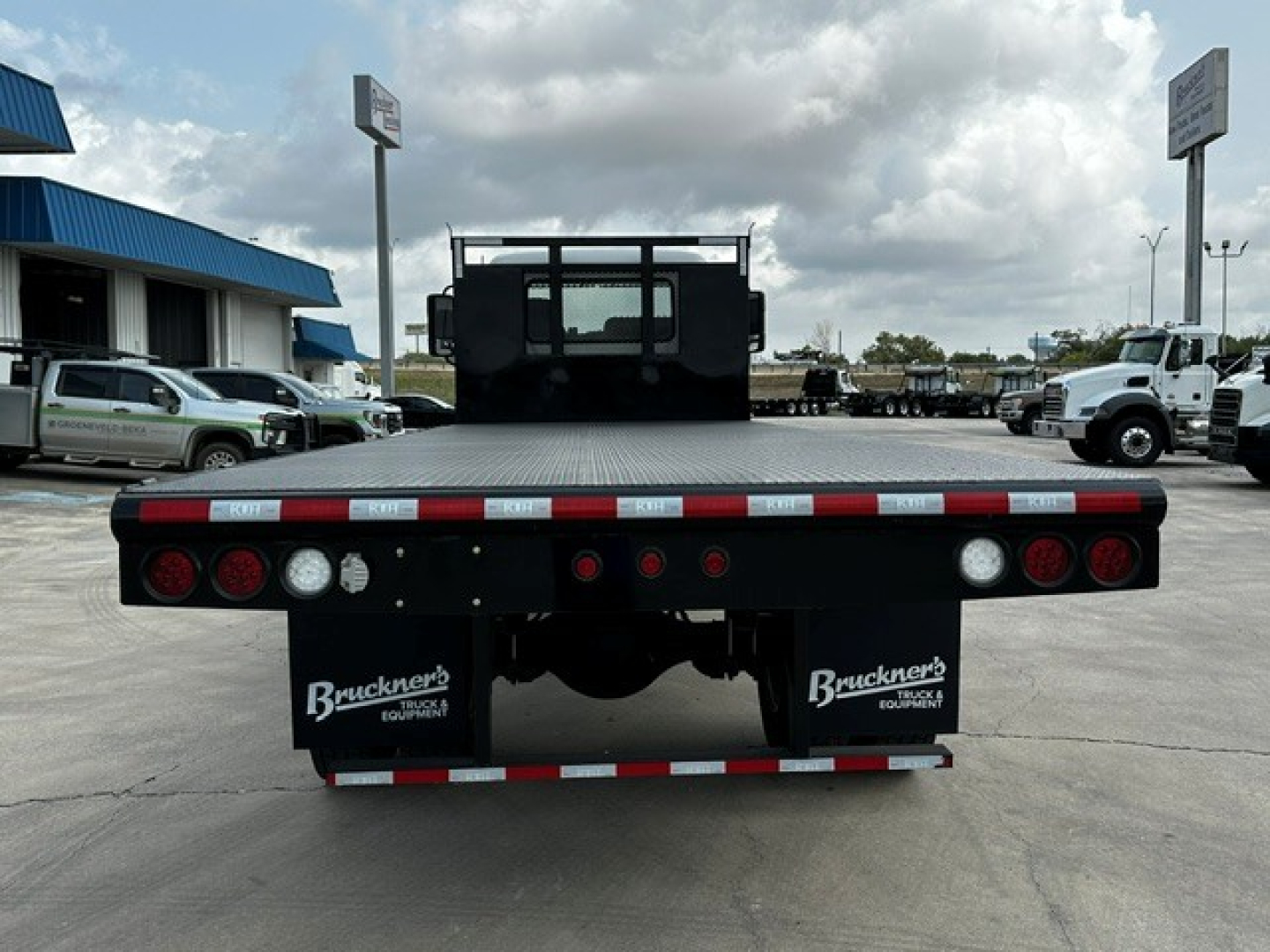 Flatbed truck rear showing bumper and taillights on a 2026 Mack MD6, with Bruckner's branding on mud flaps.
