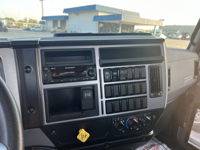 Dashboard of a 2026 Mack MD6 showing the infotainment head unit, climate controls, and multiple switches in a flatbed truck interior.