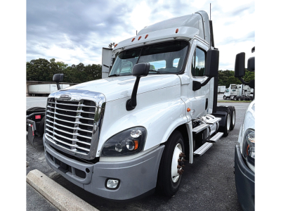Truck cab: white 2020 Freightliner Cascadia125 conventional daycab, front-left angle, showing chrome grille, headlights, side mirrors, and steps.