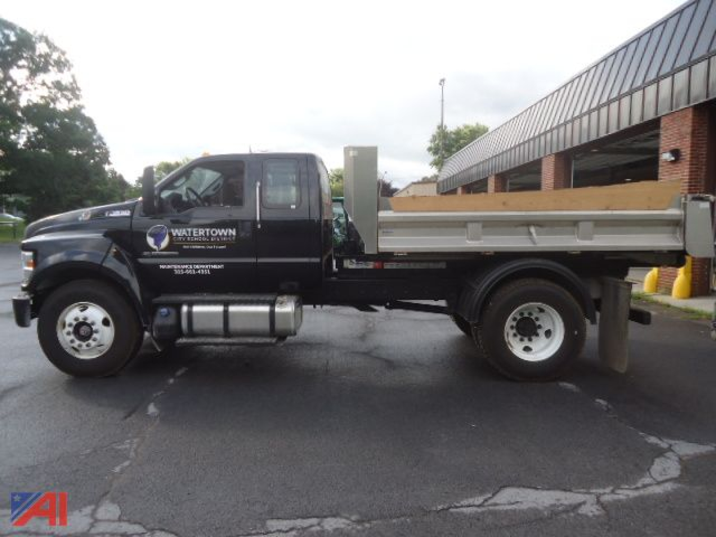 Ford F-650 Super Duty Roll Off dump truck side view showing waterTown logo on door and dump bed with rear hoist.