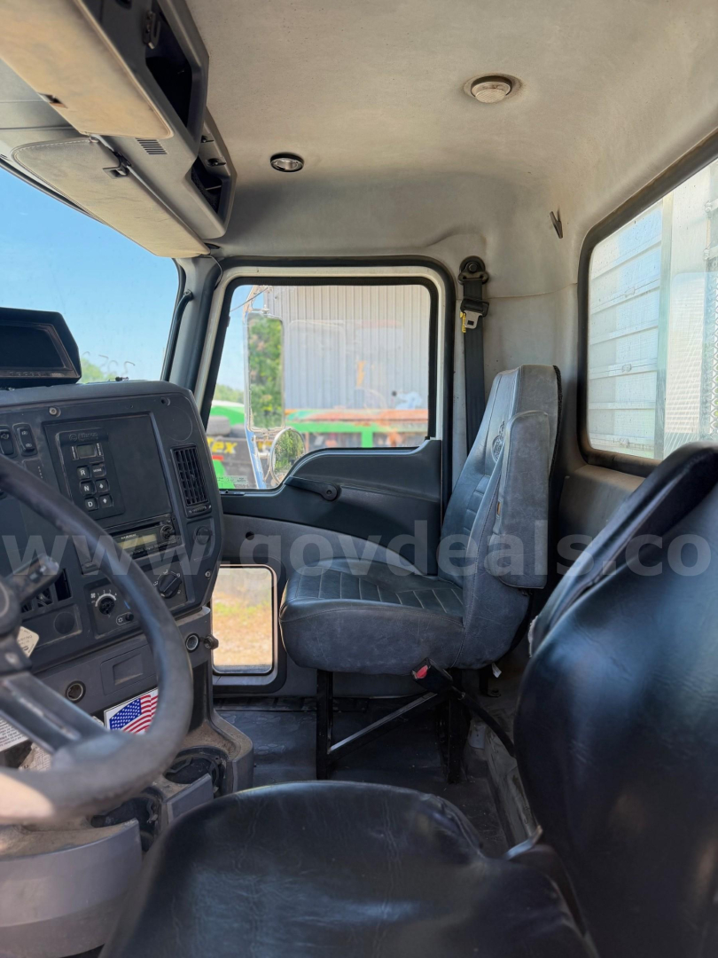 Cab interior of a Mack Granite truck showing driver seat and dashboard with steering wheel and control panel