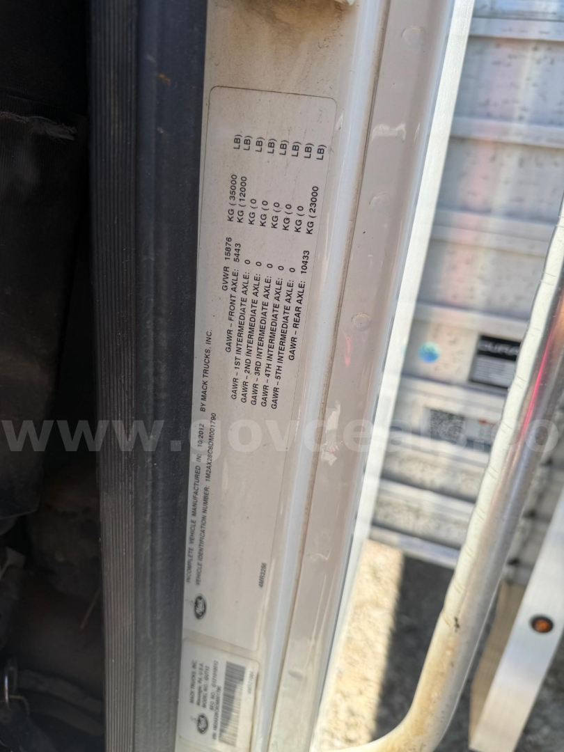 Label plate with vehicle spec codes inside Mack Granite cab area showing weight and tire codes.