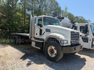 2013 Mack Granite heavy-duty truck with flatbed, front view showing Mack grille and front bumper.
