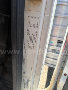 Label plate with vehicle spec codes inside Mack Granite cab area showing weight and tire codes.