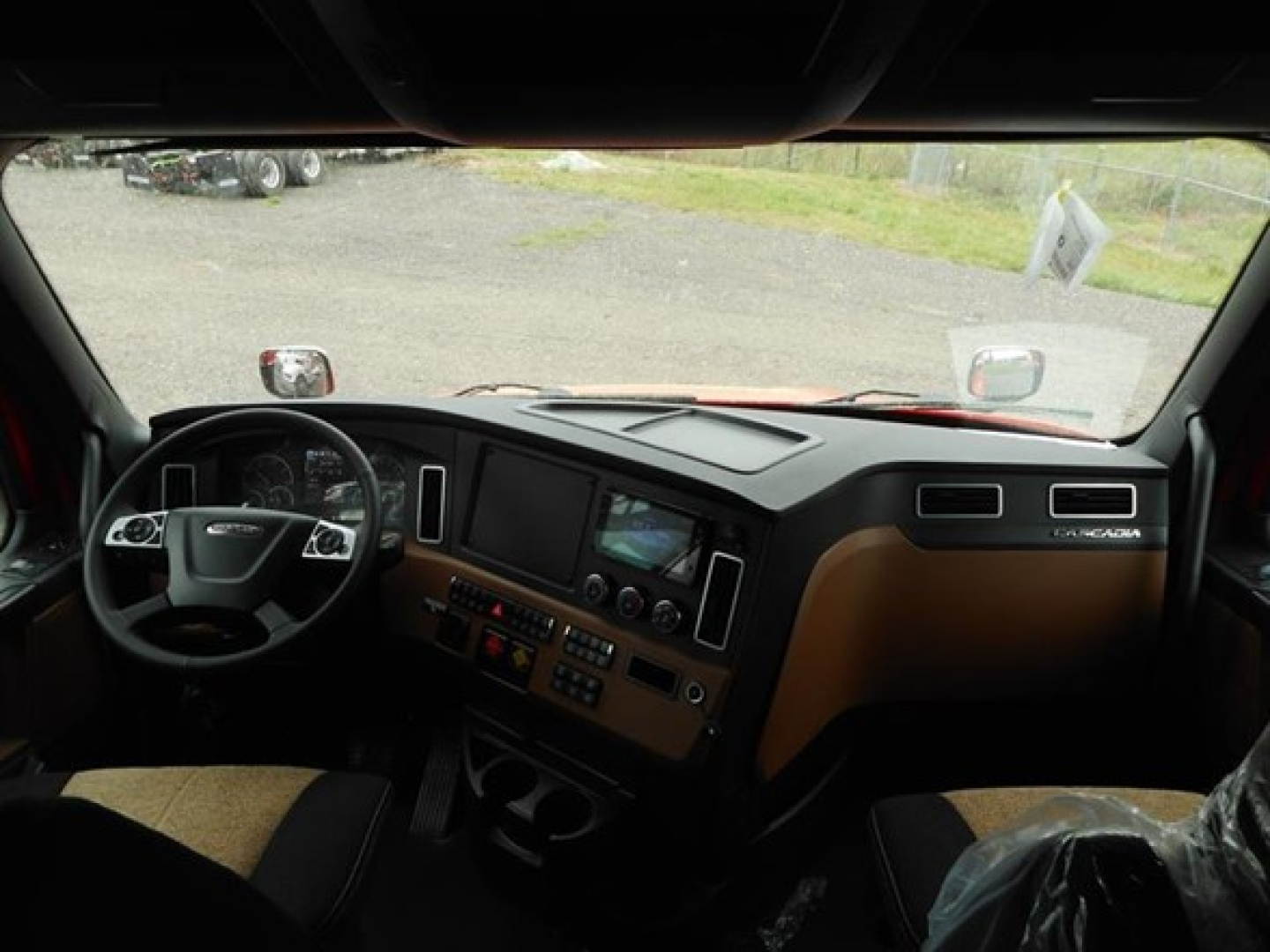Freightliner Cascadia 126 dash and steering wheel view from cab interior showing dashboard gauges and center console.