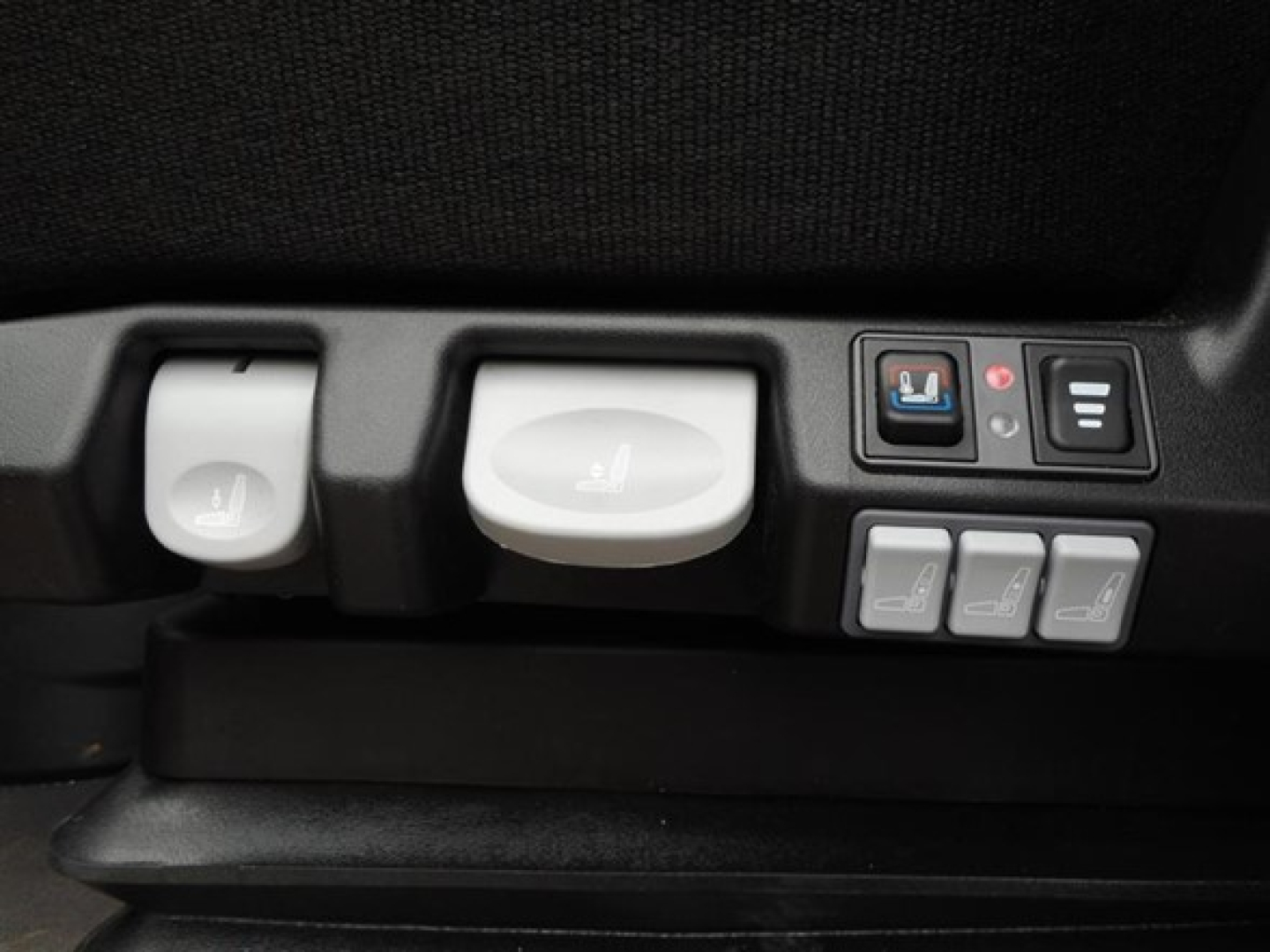 Freightliner Cascadia interior controls: seat adjustment dials, buttons for seats, and window/seat controls visible in cabin.