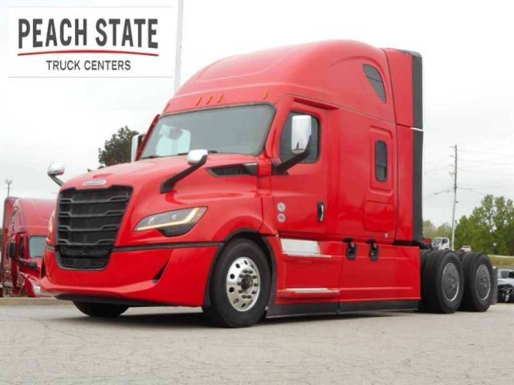 Freightliner Cascadia 126 tractor-trailer in red at Peach State Truck Centers showing side view and cab detail.