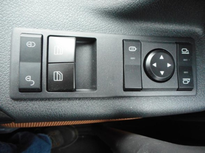Truck interior showing window/mirror control panel with four buttons and joystick on dash.