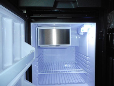 Refrigerator/freezer unit in a Freightliner Cascadia 126 cab interior with open doors.