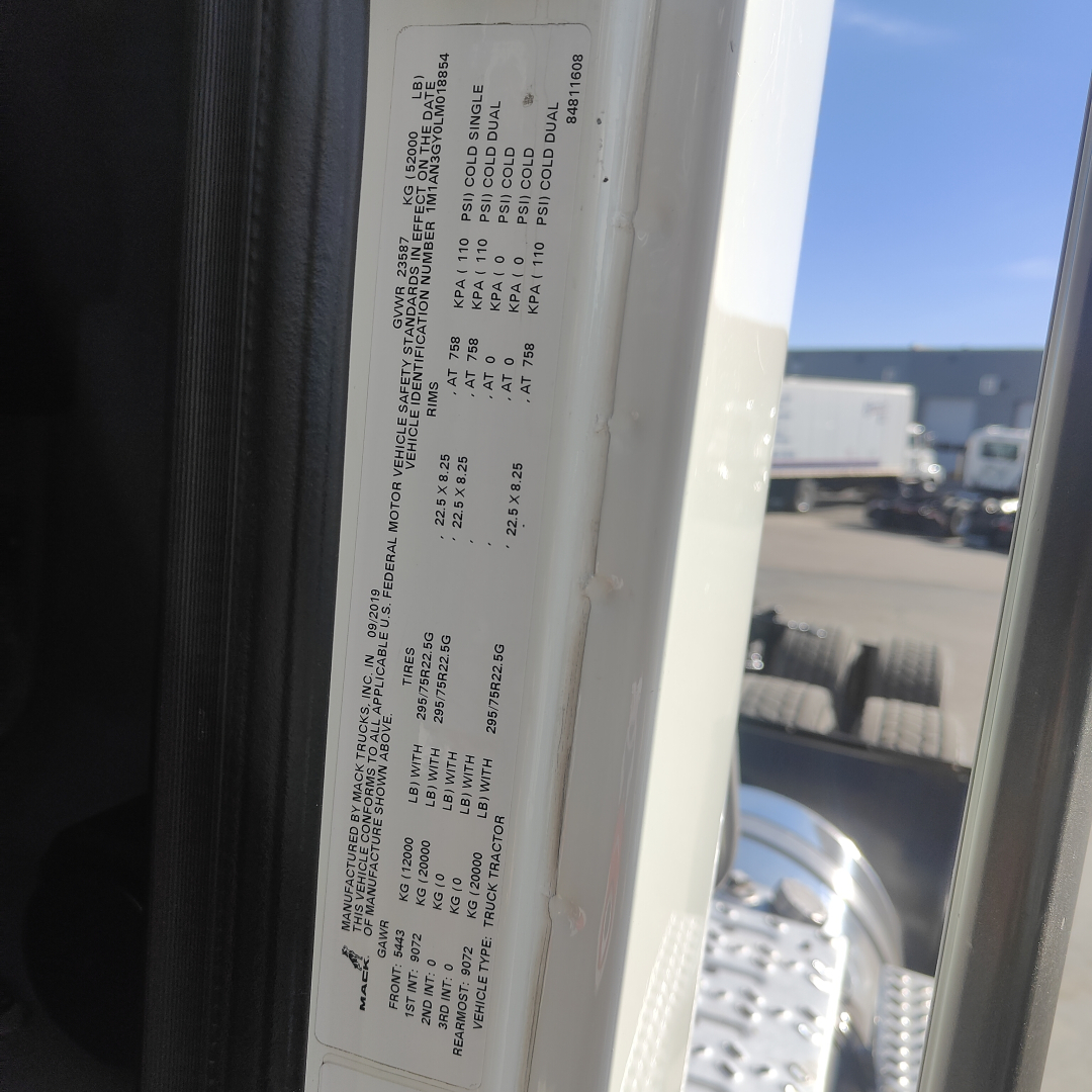 Truck cab door sticker with vehicle specifications and tire/axle data visible in the door jamb.