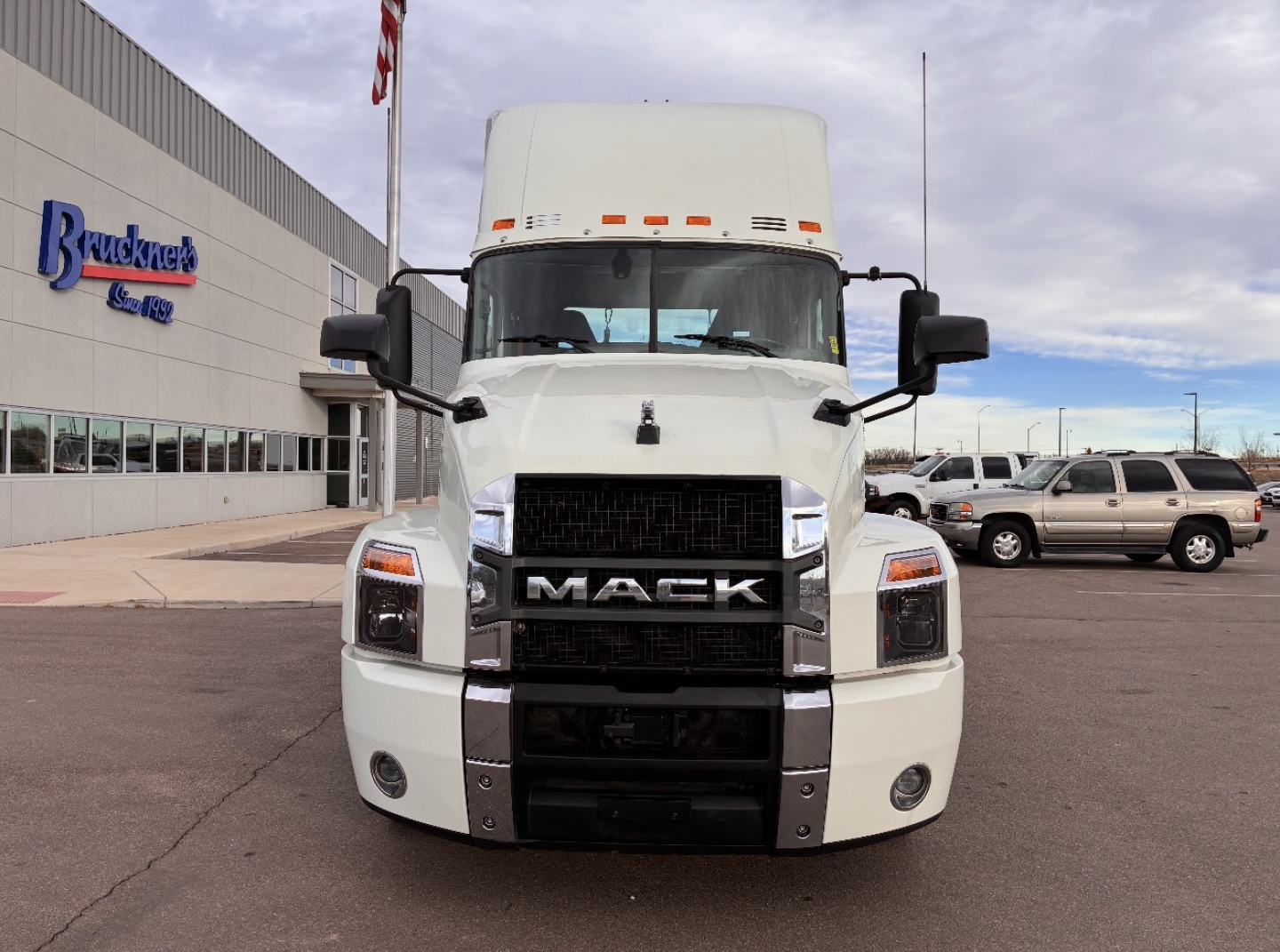 Mack AN64T conventional daycab truck front view showing grille with MACK lettering and vertical headlights.