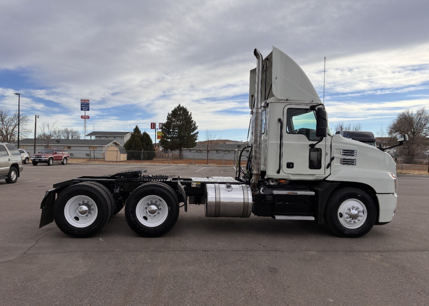 Mack AN64T conventional daycab truck side view showing chassis and cab with 3 axles and fuel tank.
