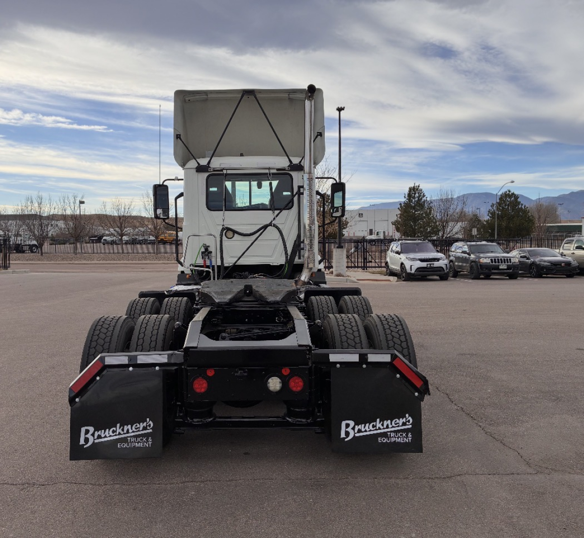 Truck chassis rear view showing sixth wheel tandem and mud flaps with Bruckners equipment logos.