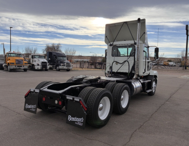 Truck rear view showing fifth wheel and dual rear axles of a white 2020 Mack AN64T conventional daycab with Brunker’s mud flaps.