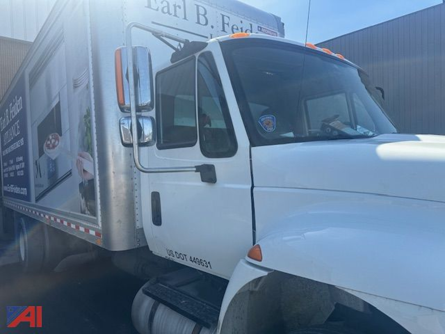 International DuraStar 4300 box truck in-service showing front cab and side advertisement panel.