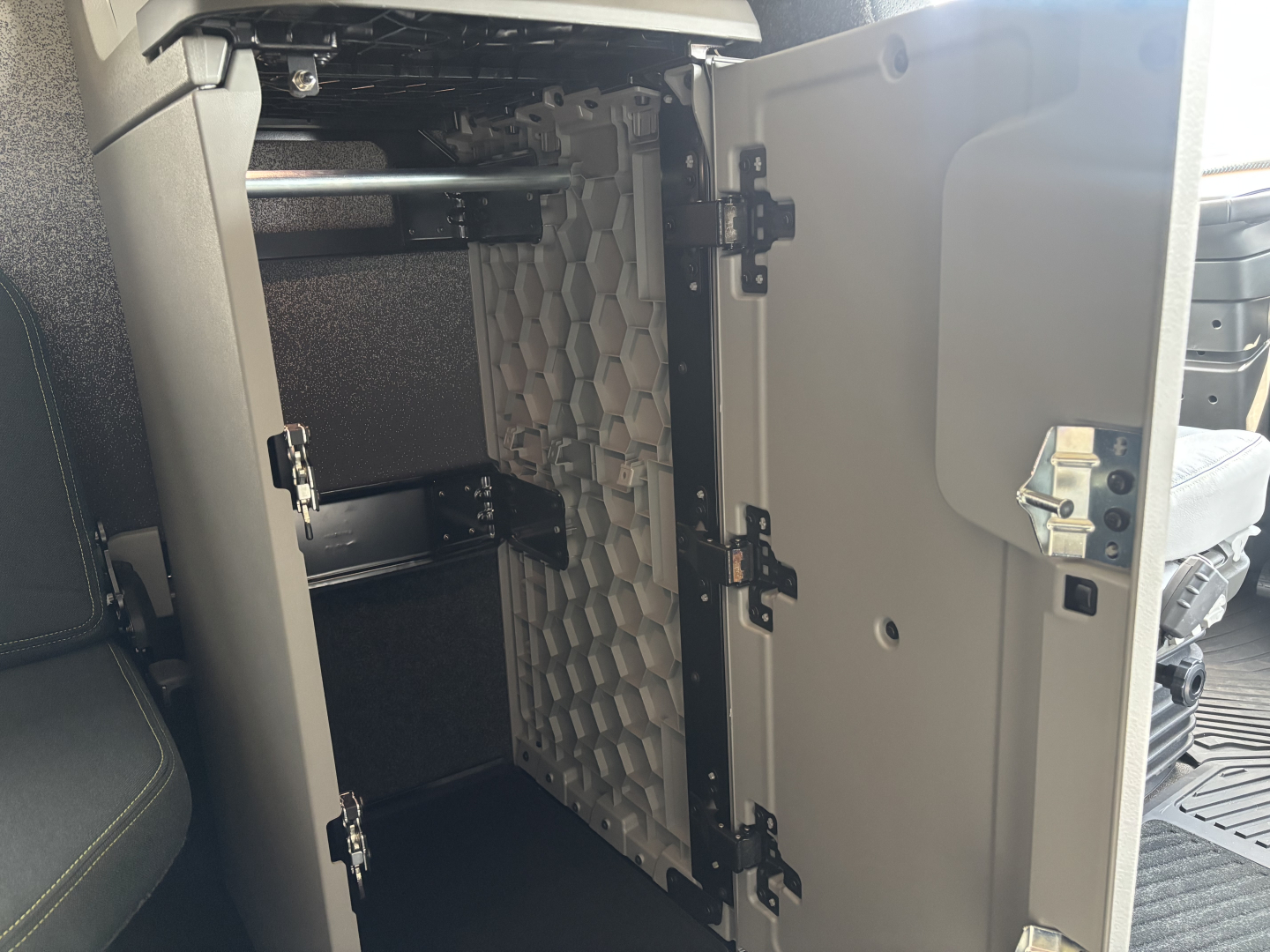  Volvo VNL64T860 cabin interior showing a vertical panel with a honeycomb-patterned separator behind a luggage/compressor area.