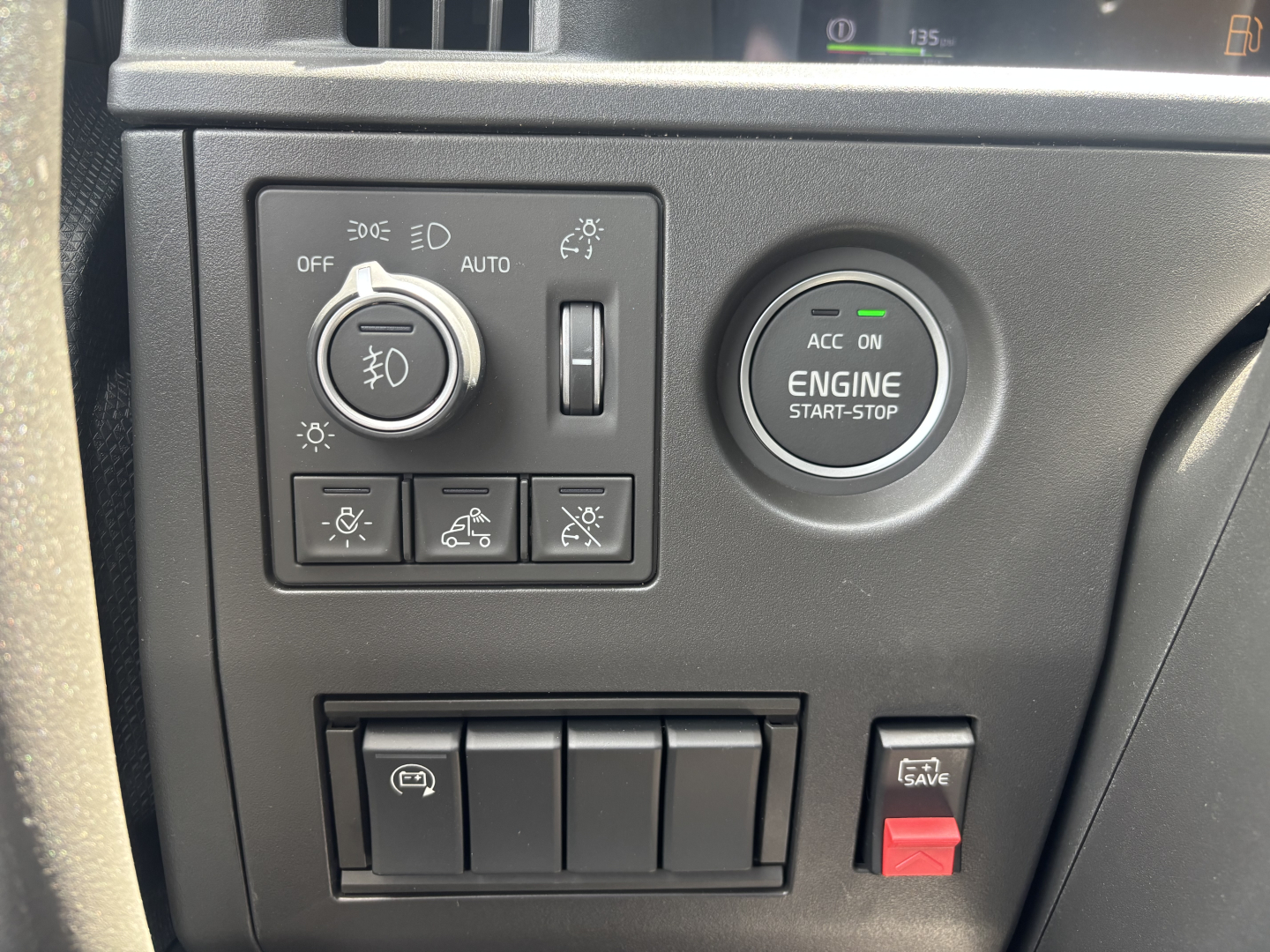 Volvo VNL64T860 dash area showing engine start-stop button, headlight controls, and various switch panels.