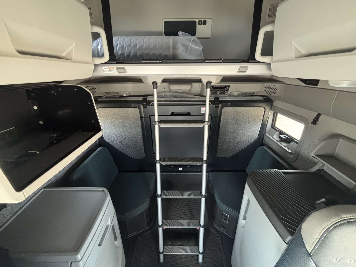 Volvo VNL64T860 truck interior: top bunk with ladder, side cabinets, and sleeper area visible