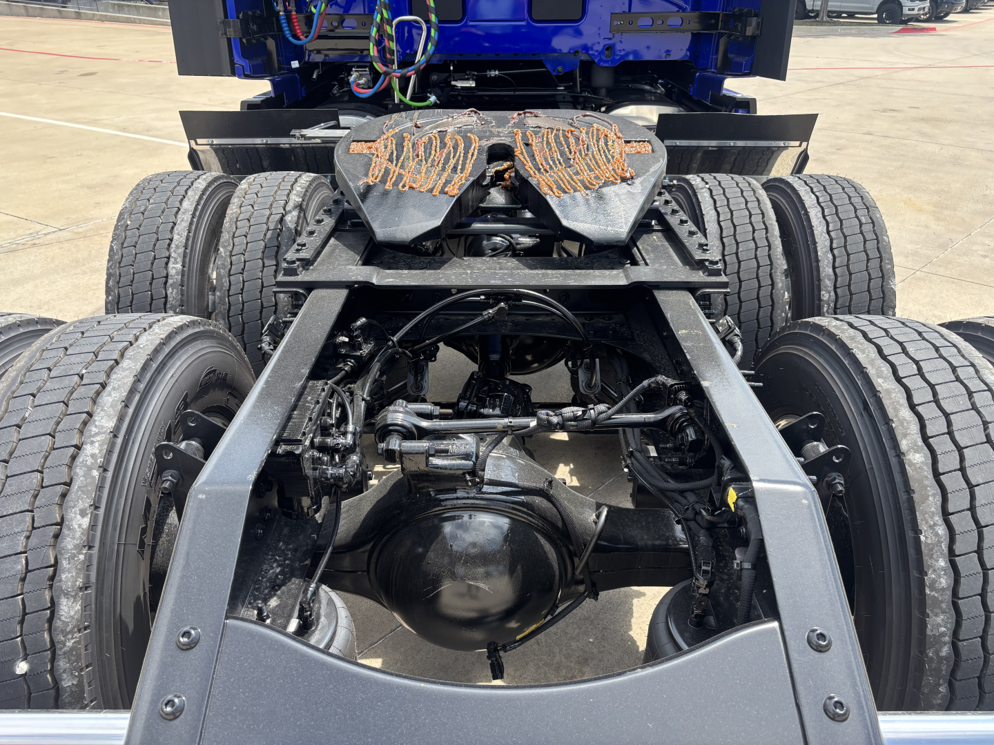 Rear view of a Volvo VNL truck chassis showing dual rear axles, suspension, and drivetrain components; no text visible apart from general truck parts.