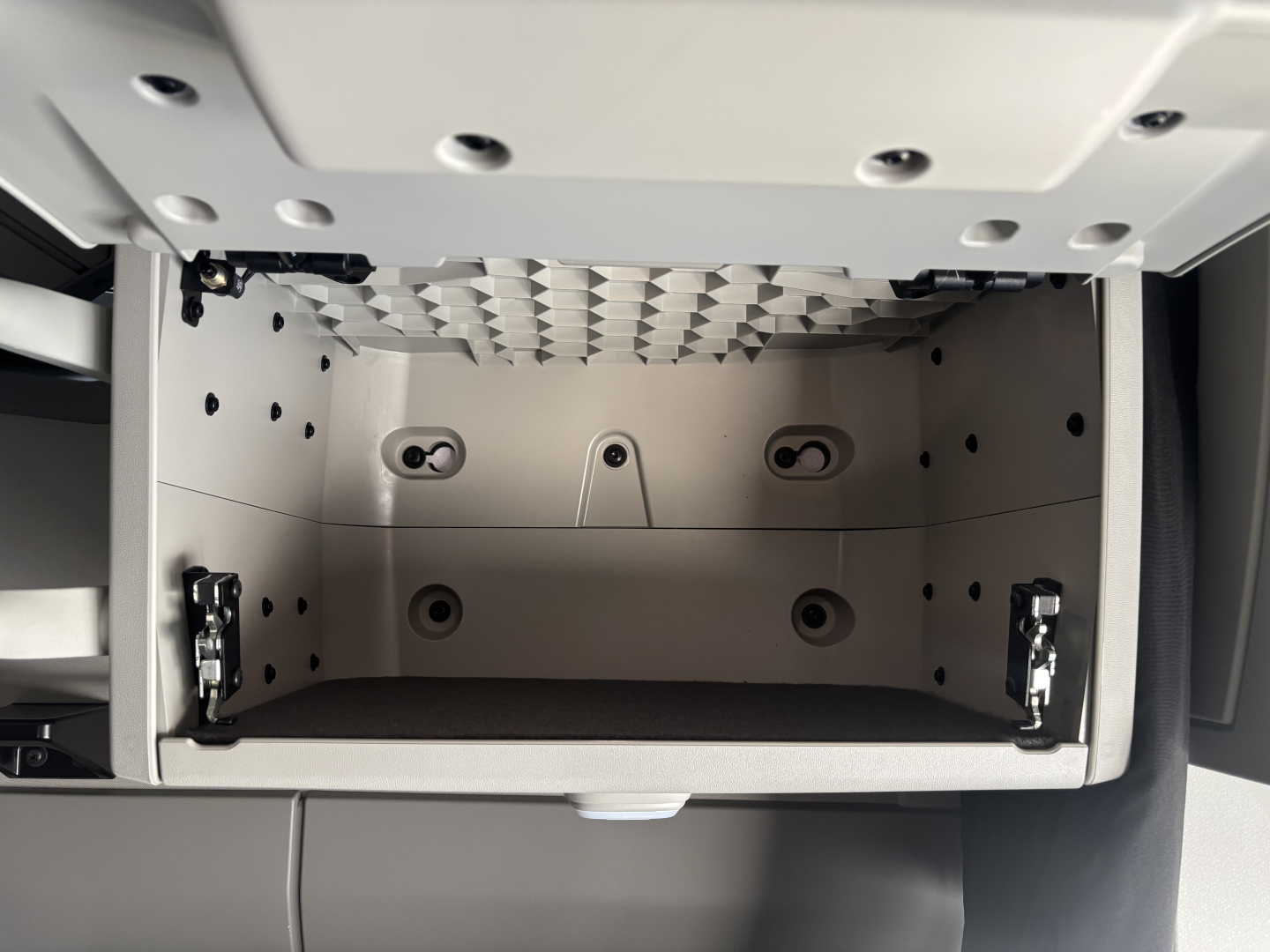 Volvo VNL64T860 truck cab storage area with empty overhead toolbox compartment showing metal interior and mounting points.