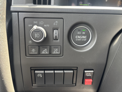 Volvo VNL64T860 dash area showing engine start-stop button, headlight controls, and various switch panels.