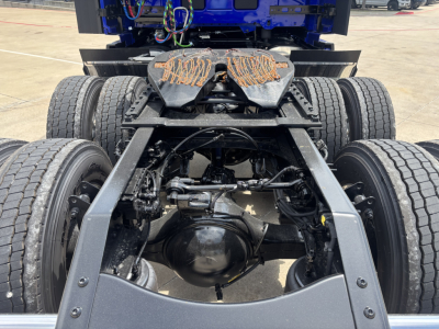 Rear view of a Volvo VNL truck chassis showing dual rear axles, suspension, and drivetrain components; no text visible apart from general truck parts.