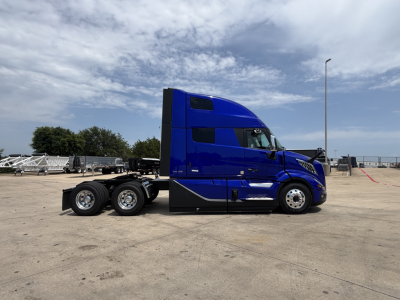 Volvo VNL64T860 tractor in blue side view showing sleeper cab and rear dual axles.