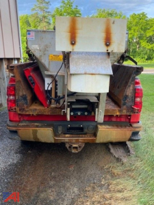 Chevrolet Silverado 3500HD rear view with plow and sander equipment mounted in bed; rust spots on hopper; tailgate area visible; VIN visible tag area.
