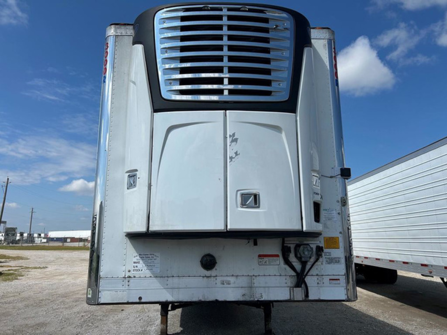 Rear view of a 2020 Utility refrigerated trailer with a blue-grille cooling unit, white body, and storage hitch area, visible stock number U91149 and VIN label.
