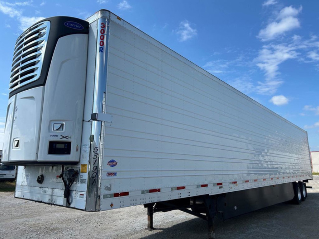 Refrigerated trailer with Thermo King unit at the front showing multiple side panels and wheels, utility reefer trailer in a lot.