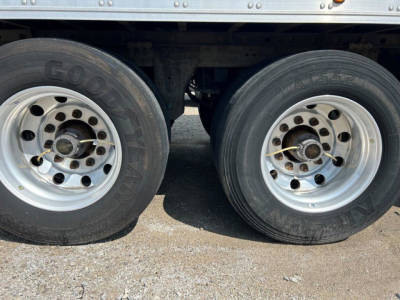 Dual rear trailer wheels with Goodyear tires and silver rims, undercarriage visible.